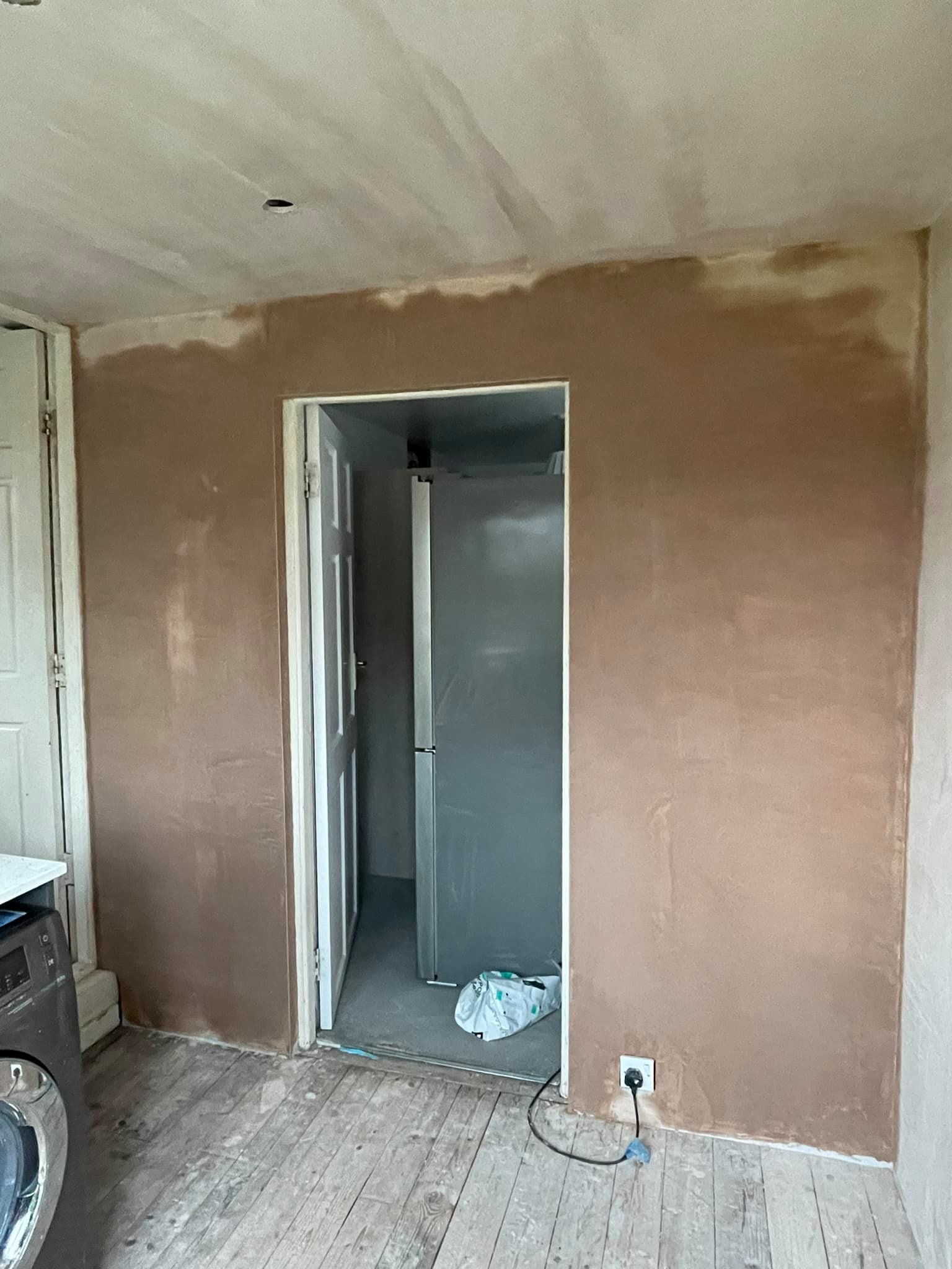 Utility room wall freshly plastered around a doorway