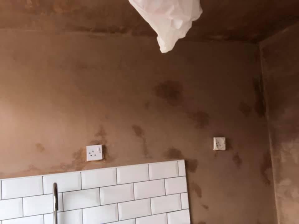 Freshly plastered kitchen wall above white metro tiles